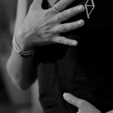 A woman practicing breathing exercises with one hand on her chest and the other on her stomach, wearing a t-shirt with the ALTYR logo on it