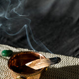 a burning palo santo stick and its smoke going through the air