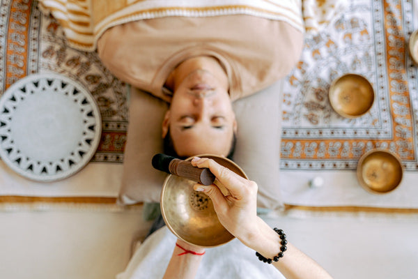 Man Relaxing while Listening to Sounds From a singing bowl