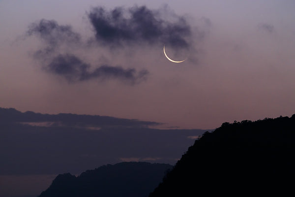 New moon rises over the mountains