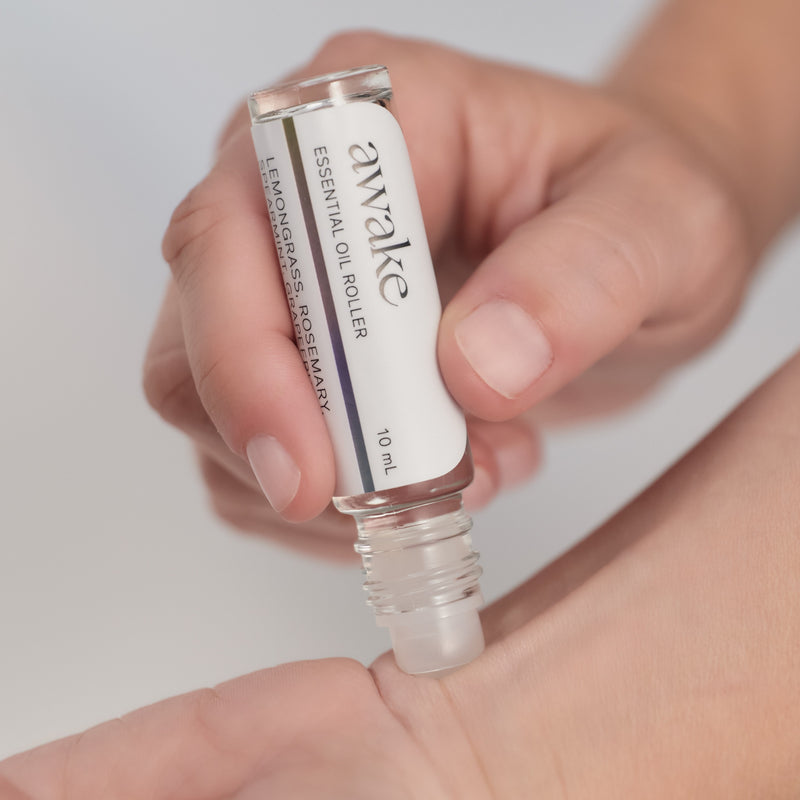 A person using Awake Essential Oil Roller on her wrist