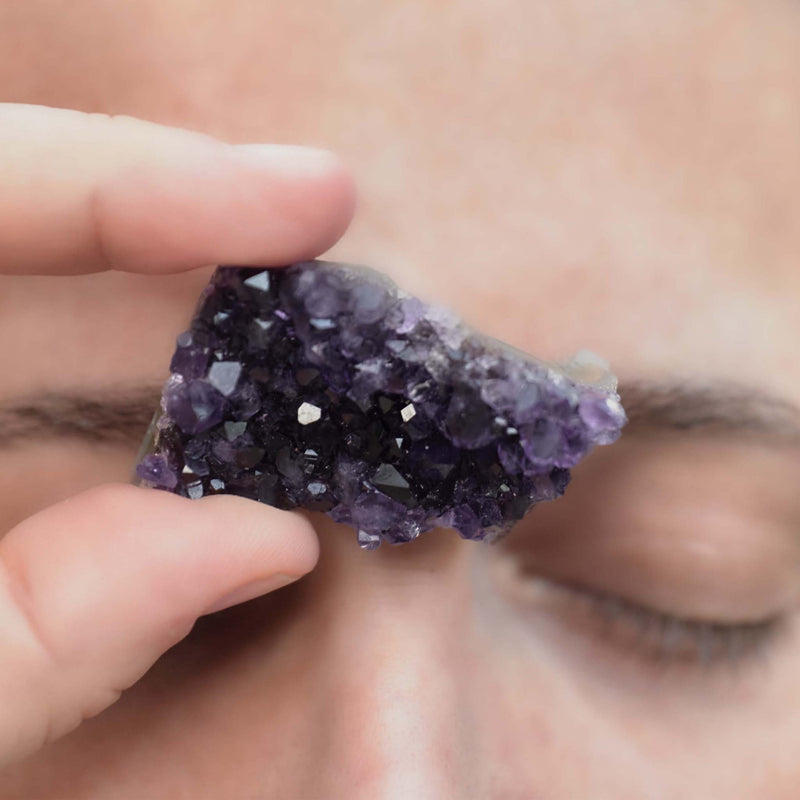 A woman holding an amethyst stone in her hand 