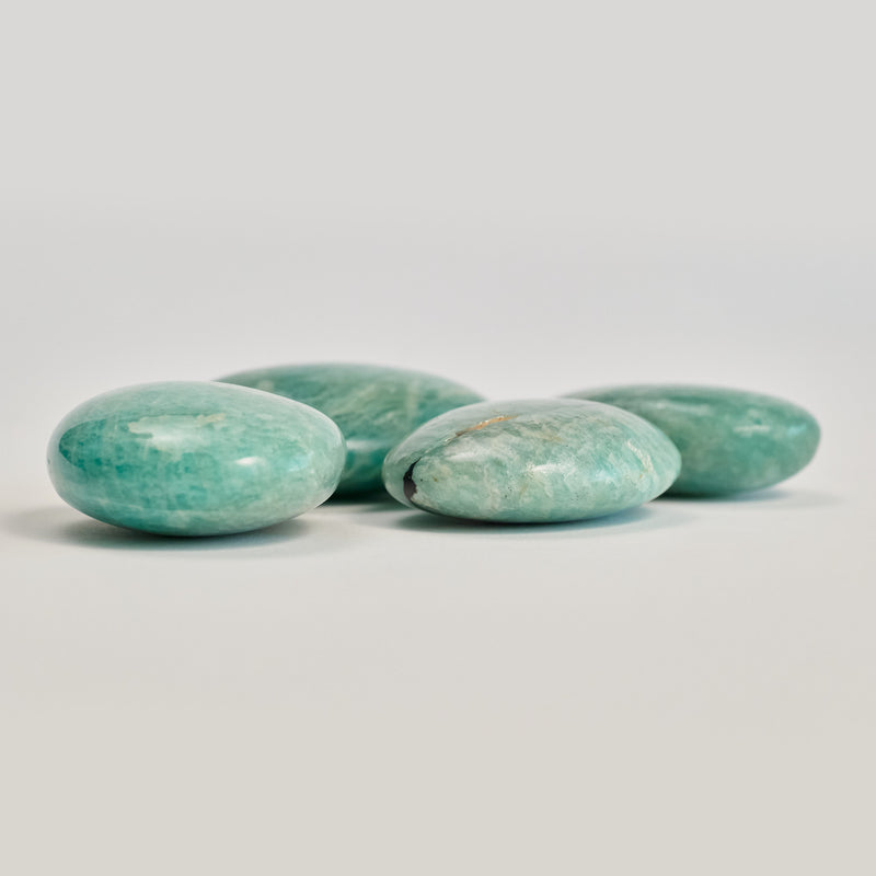 Four amazonite stones on a white floor