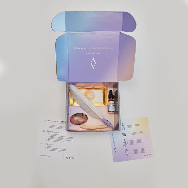  Altyr Toolkit: Attract Love box with simple aura colored design including Boundless Love Heart Elixir Herbal Tincture, Ceremonial Grade Cacao, Rhodonite Gemstone, Palo Santo and Smudging Feather