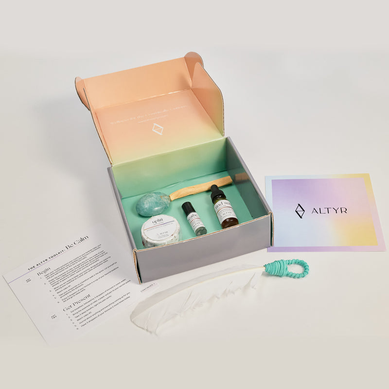 Altyr Toolkit: Be Calm box with simple aura colored design including Amazonite Stone, Palo Santo and Smudging Feather, Find Serenity Calm Elixir Herbal Tincture, Breathe Essential Oil Roller and Uplift Rose Bath Bomb